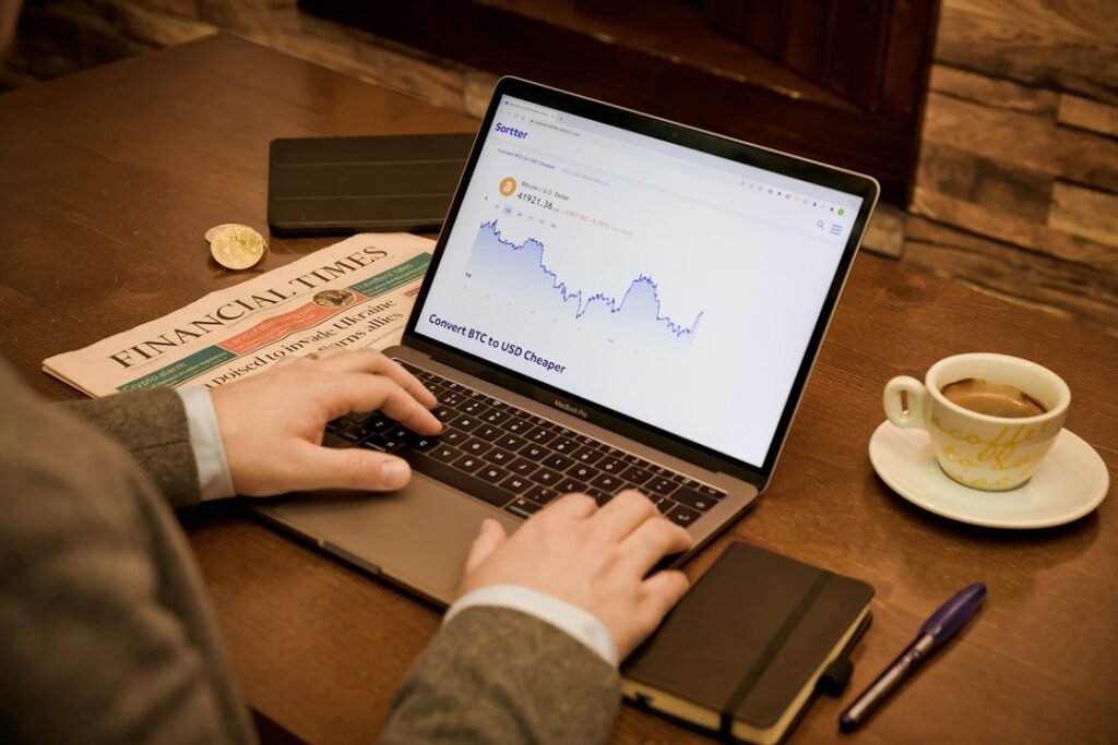 Person checking cryptocurrency and financial charts on a laptop